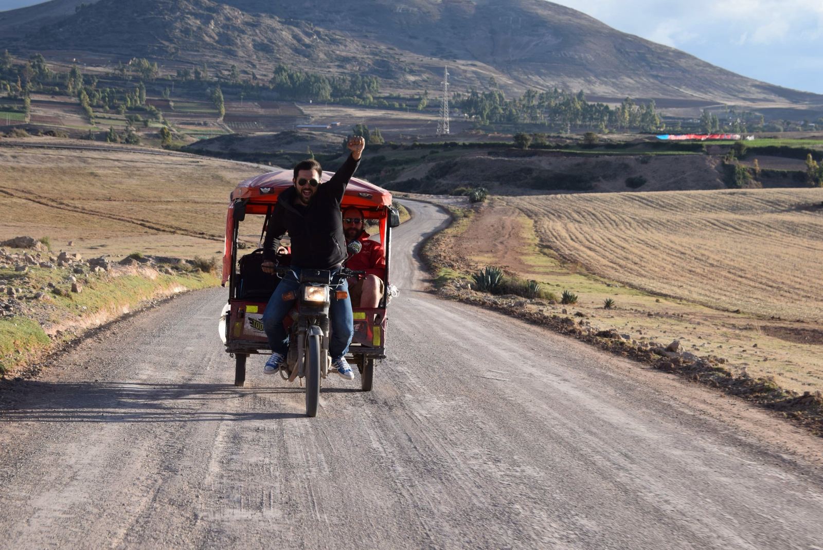 Vlad with the Machu Beast mototaxi on a road in Peru