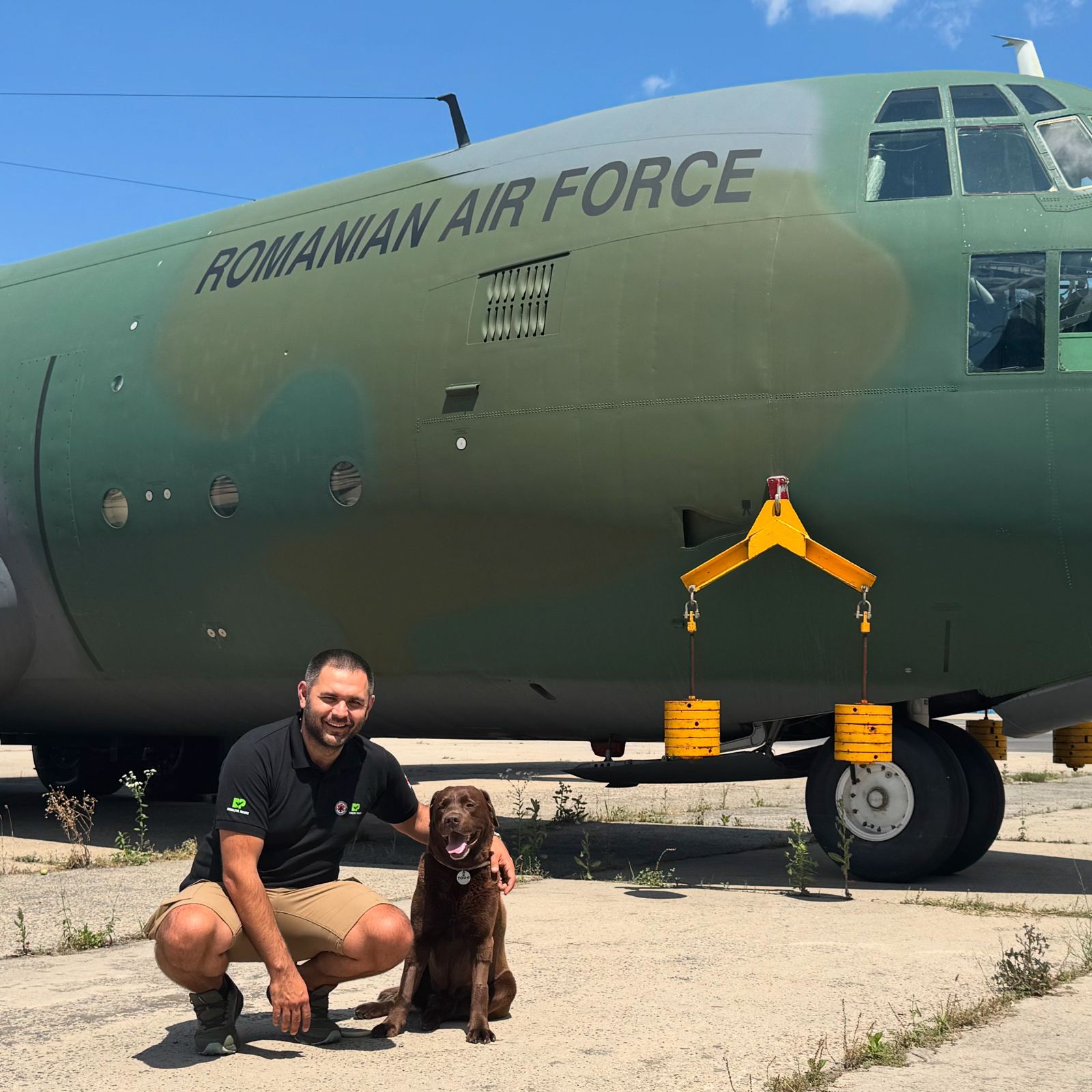 Vlad crouching next to Toshi, his search and rescue dog